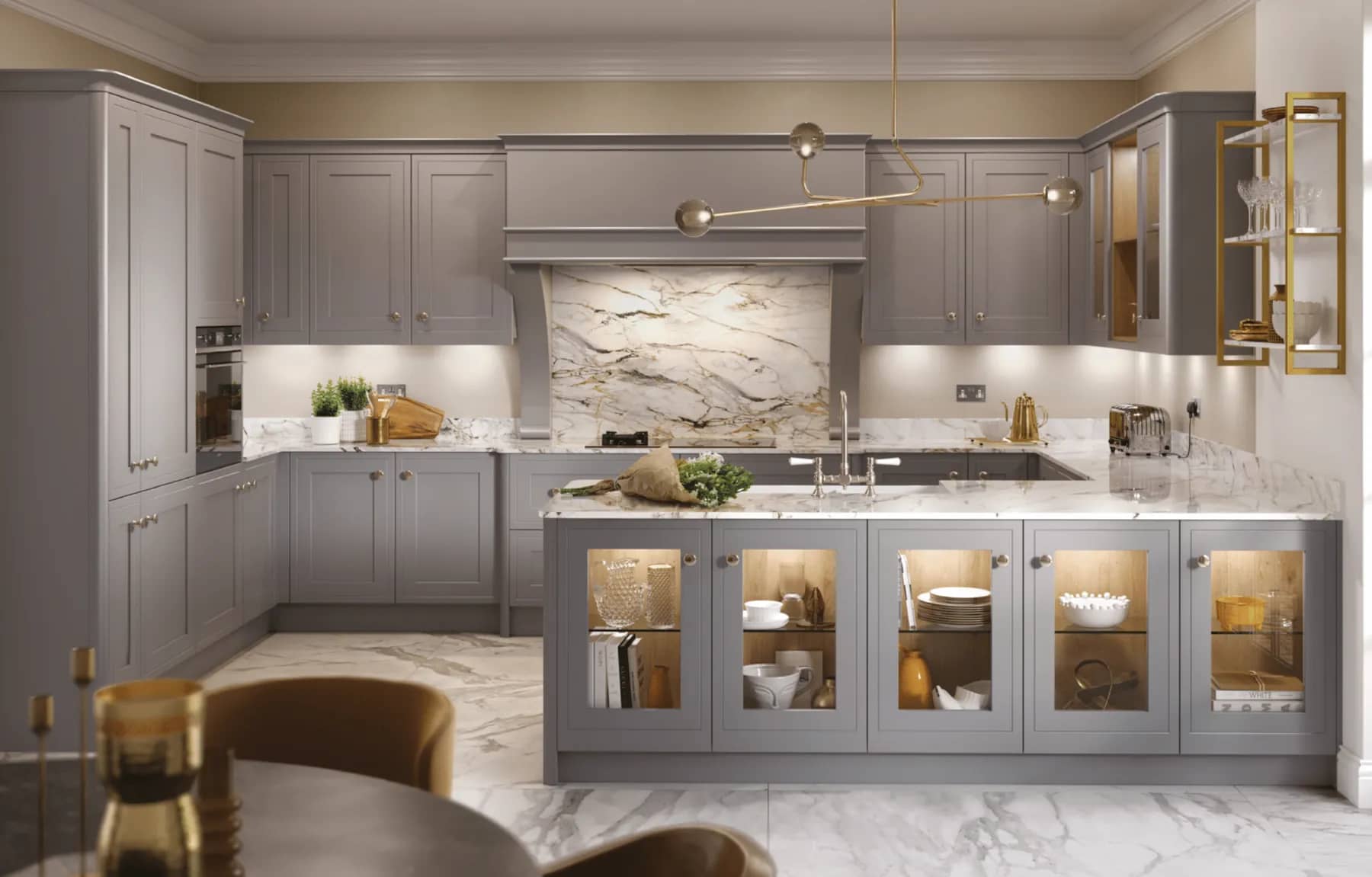 Dove grey shaker kitchen with marble worktops, a marble splashback and glazed display cabinets lit from within.