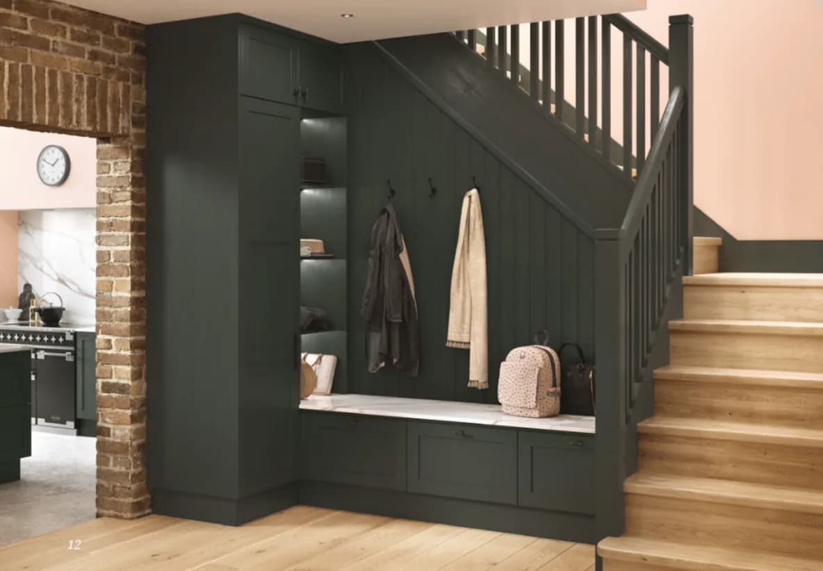 Fitted boot room in sage green with a bench and hanging space
