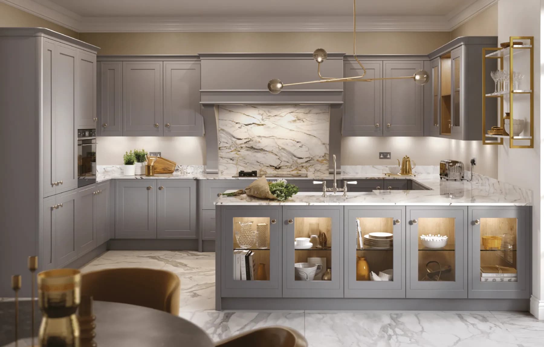 Light grey in-frame cabinetry with a veined marble worktop and splashback, and glazed display cupboards along the peninsula