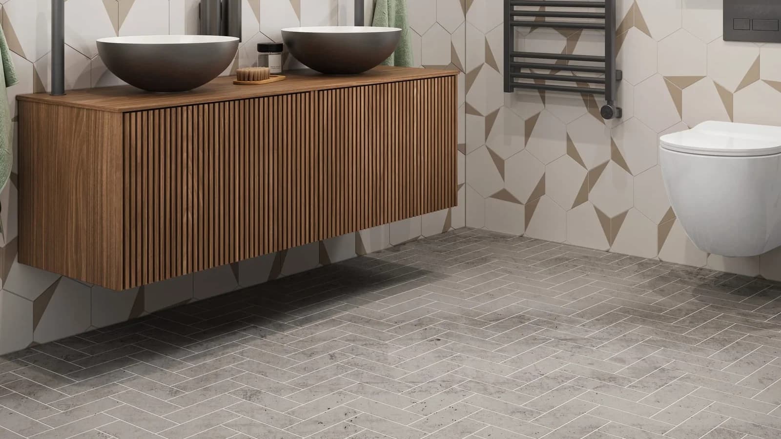 Grey stone-look tile laid in herringbone under a fluted walnut vanity